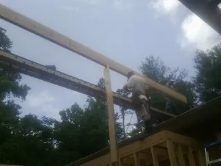 Carpenter setting a ridge beam over a new addition frame — Ice Dam Removal by Roofing Brothers in Declo