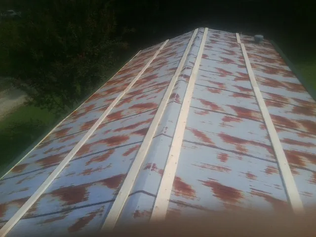 Rusted metal roof panels with new wood purlins before replacement — Storm Damage Roof Repair in Declo by Roofing Brothers