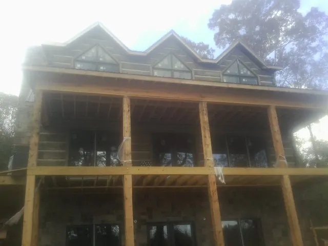 Dormers and porch framing on a large log home under construction — Roof Coating work by our crew in Declo