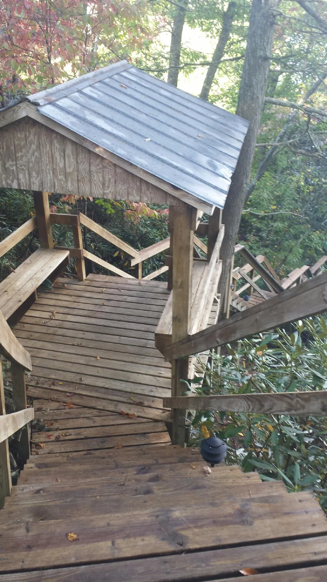 Metal roofed shelter over wooden steps on a wooded walkway — Skylight Repair & Installation work by our crew in Declo